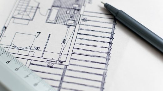 Plan budowy domu z linijką i ołówkiem na biurku projektanta.