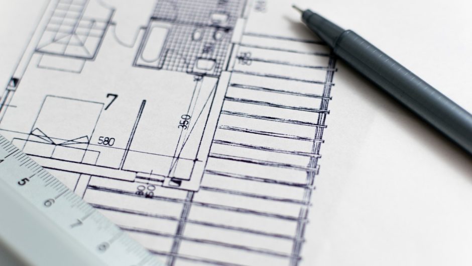 Plan budowy domu z linijką i ołówkiem na biurku projektanta.